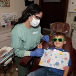 Dental Hygienist with smiling child patient in dental chair