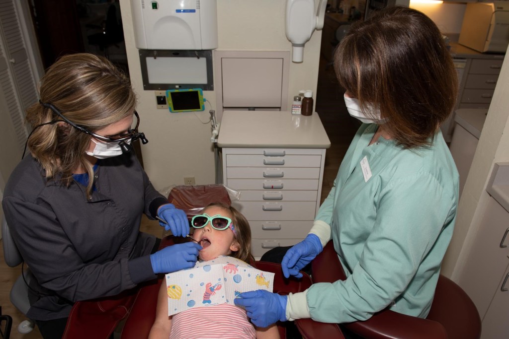 Dr. Munselle checking child's teeth in Healdsburg