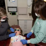 Dr. Munselle checking child's teeth in Healdsburg